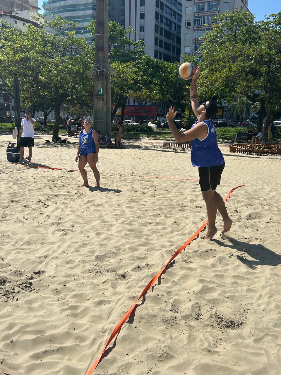 Jogador de futevôlei saltando para cortar a bola na rede